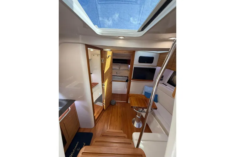 Slide: The Image of 2024 Boston Whaler 405 Conquest interior with wood flooring and seating area. - 12
