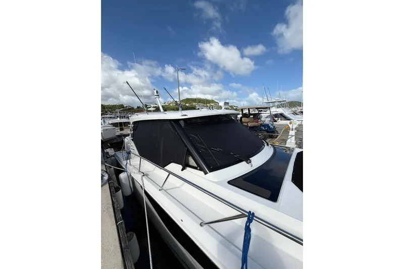 Slide: The Image of 2024 Boston Whaler 405 Conquest docked under a clear blue sky. - 13