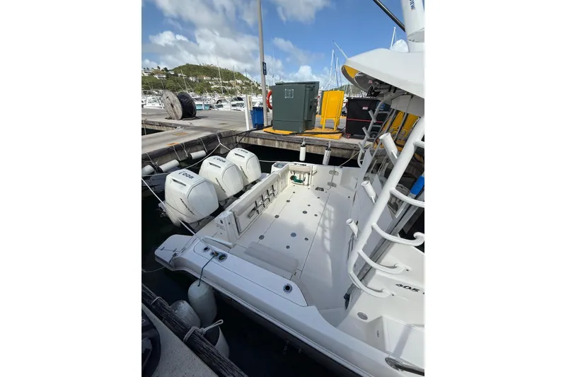 Slide: The Image of 2024 Boston Whaler 405 Conquest docked, showcasing powerful outboard engines and spacious deck. - 15