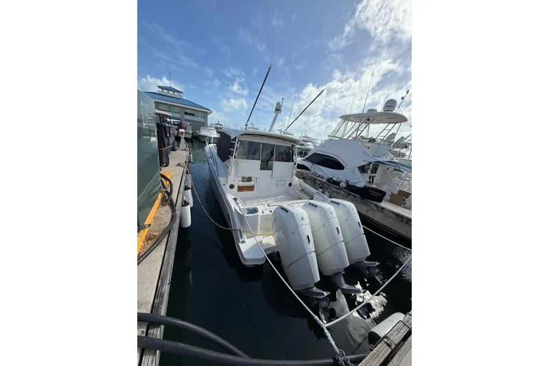 Slide: The Image of 2024 Boston Whaler 405 Conquest docked at marina under blue sky. - 16