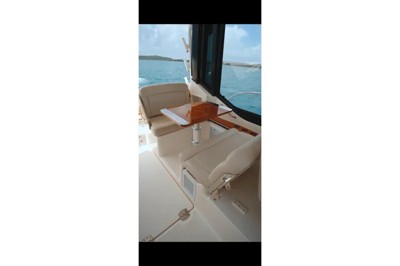Slide: The Image of 2024 Boston Whaler 405 Conquest interior with seating and table, overlooking the ocean. - 4