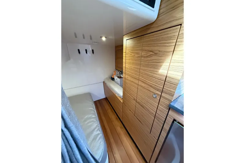 Slide: The Image of 2024 Boston Whaler 405 Conquest cabin interior with wood paneling and seating. - 7