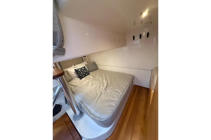 Slide: The Image of 2024 Boston Whaler 405 Conquest cabin interior with cozy bed and modern design. - 8