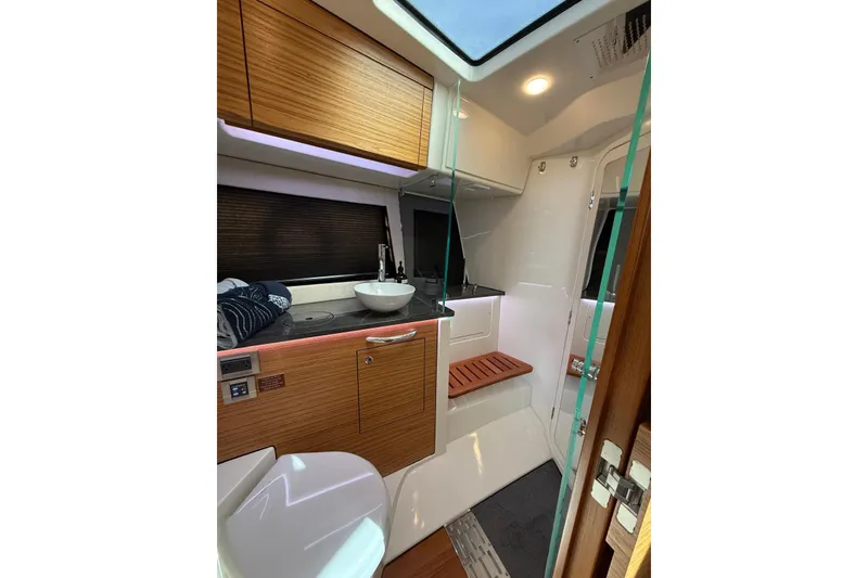 Slide: The Image of 2024 Boston Whaler 405 Conquest interior bathroom with modern fixtures and wooden accents. - 9