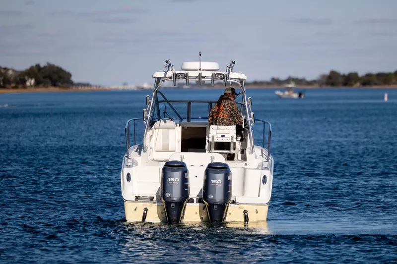 Slide: The Image of 2006 Sailfish 2660 WAC boat cruising on a calm waterway. - 11