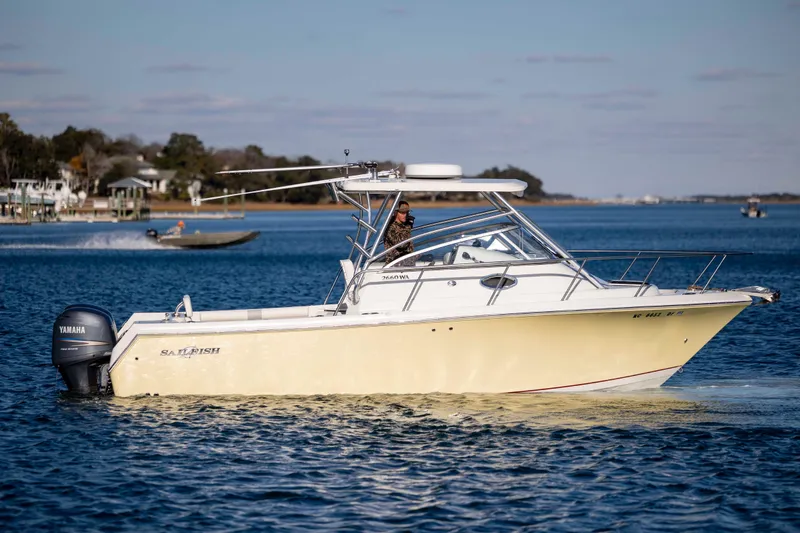 Slide: The Image of 2006 Sailfish 2660 WAC boat cruising on a calm lake with Yamaha engine. - 13