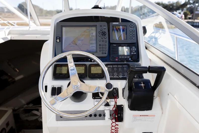 Slide: The Image of 2006 Sailfish 2660 WAC boat dashboard with steering wheel and navigation equipment. - 25