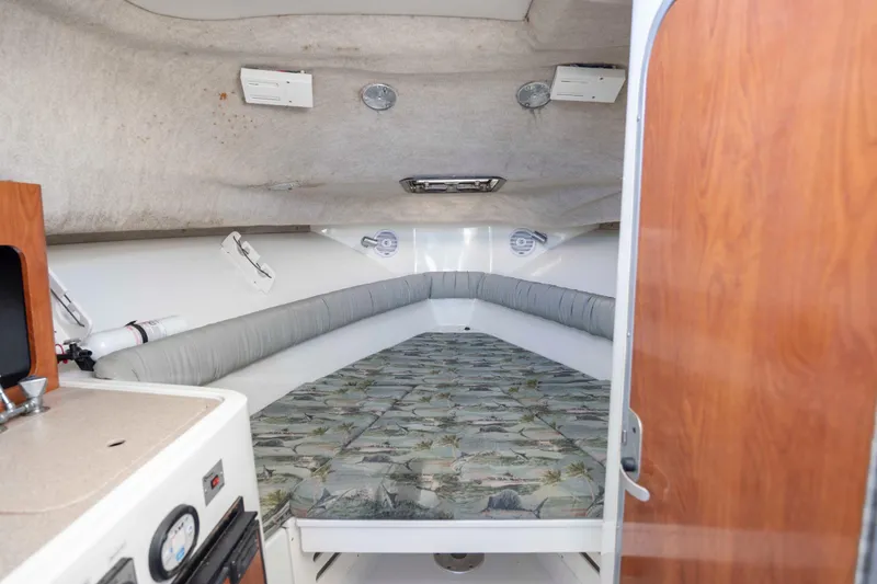 Slide: The Image of 2006 Sailfish 2660 WAC cabin interior with cushioned seating and patterned bedding. - 31