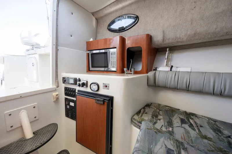 Slide: The Image of 2006 Sailfish 2660 WAC cabin interior with microwave, control panel, and seating area. - 32