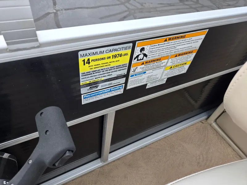 Slide: The Image of Capacity and warning labels on a 2012 Sweetwater 2486 boat, seating 14 people. - 15