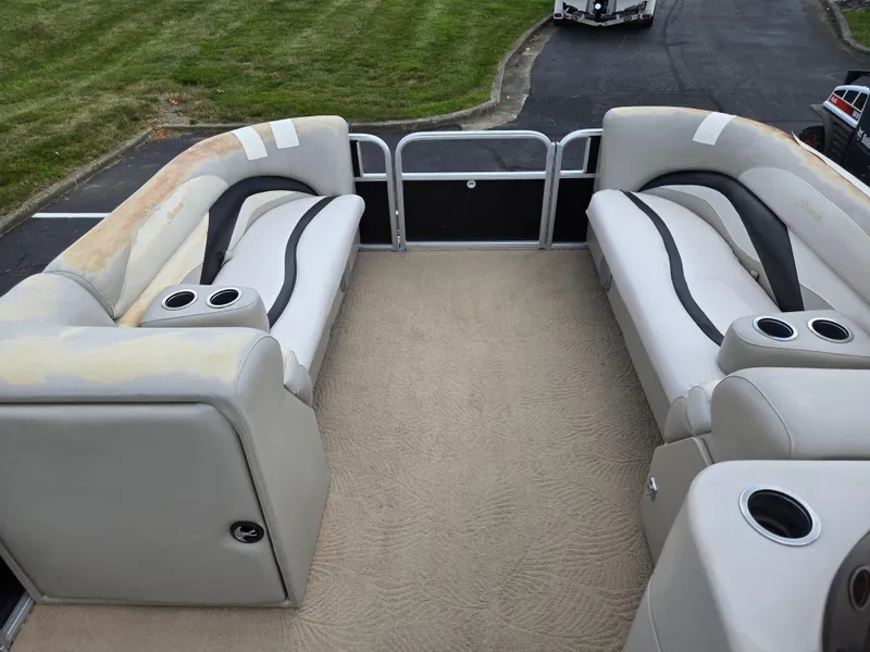 Slide: The Image of 2012 Sweetwater 2486 pontoon boat interior with beige seating and cup holders. - 23