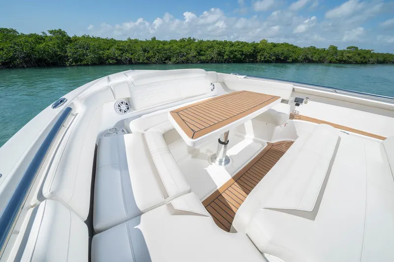Slide: The Image of Manufacturer Provided Image: Luxurious seating area on 2025 Tiara Yachts 48 LS, featuring elegant teak table and cushions. - 10