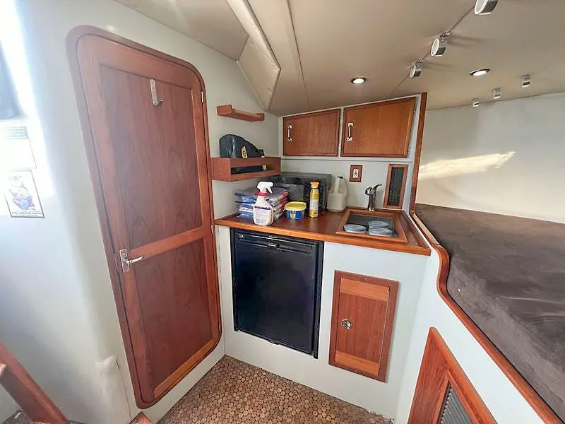 Slide: The Image of Interior of 1998 Jersey Cape 36 Express with kitchenette and storage. - 9