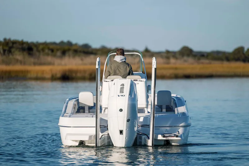 Slide: The Image of Caymas 26 HB 2026 boat on calm water, rear view. - 3