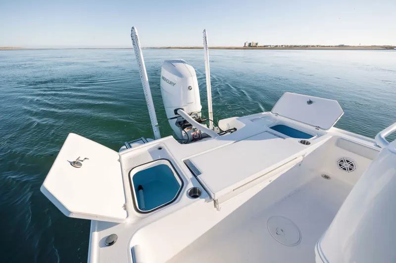 Slide: The Image of Caymas 26 HB 2026 boat with open deck and motor on calm water. - 30