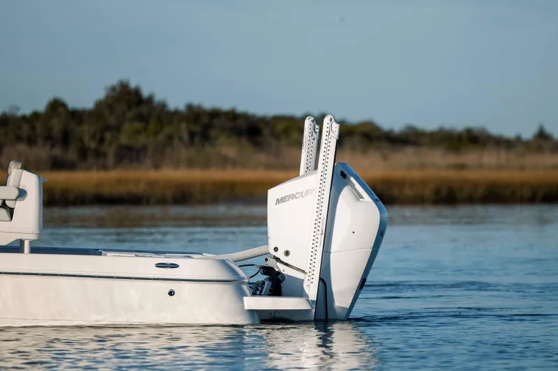 Slide: The Image of Caymas 26 HB 2026 boat on calm water with outboard motor. - 7
