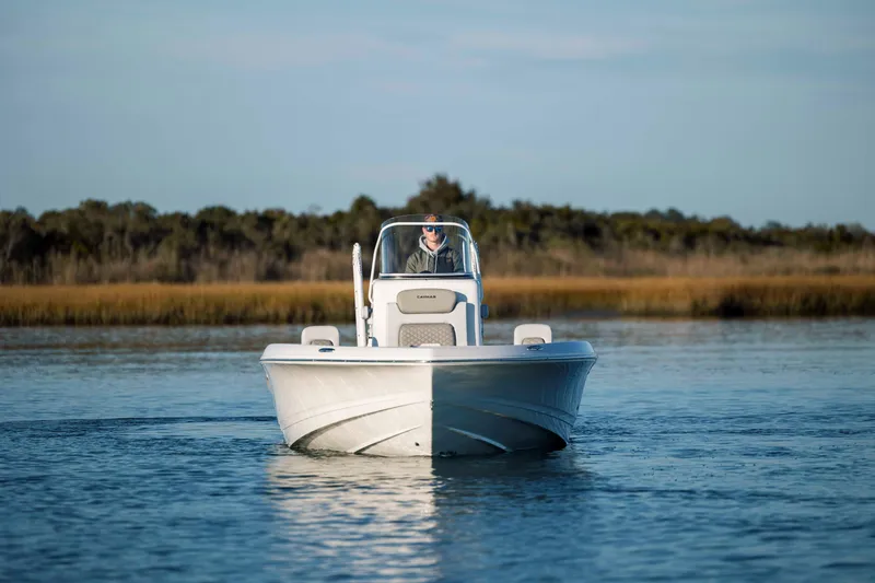 Slide: The Image of Caymas 26 HB 2026 boat on calm water with coastal backdrop. - 9