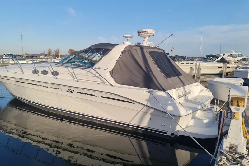 The Image of 1995 Sea Ray 400 Express Cruiser docked at marina under clear blue sky. - 1
