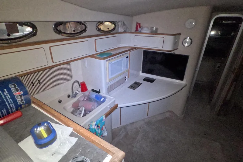 Slide: The Image of Interior of 1995 Sea Ray 400 Express Cruiser with kitchenette and TV. - 19