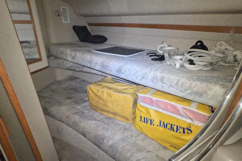 Slide: The Image of Interior of 1995 Sea Ray 400 Express Cruiser with life jackets and ropes stored on bunks. - 22