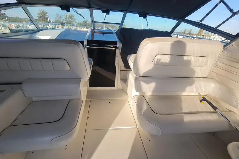 Slide: The Image of Interior of a 1995 Sea Ray 400 Express Cruiser with white seating and helm view. - 4