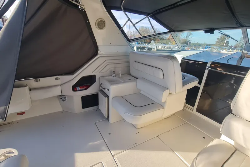 Slide: The Image of 1995 Sea Ray 400 Express Cruiser interior with white seating and helm station. - 5