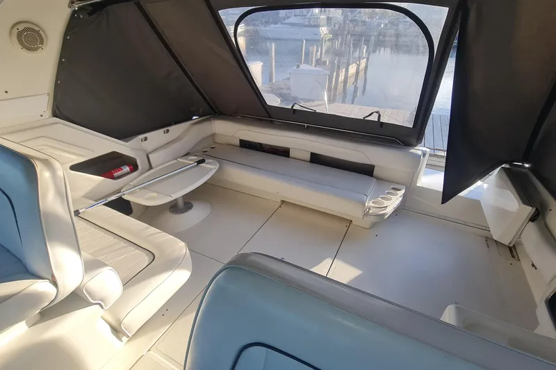 Slide: The Image of Interior of 1995 Sea Ray 400 Express Cruiser with seating and table, dock view. - 8