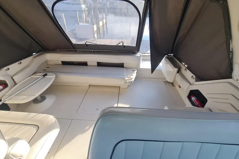 Slide: The Image of 1995 Sea Ray 400 Express Cruiser interior with seating and table, dock view. - 9