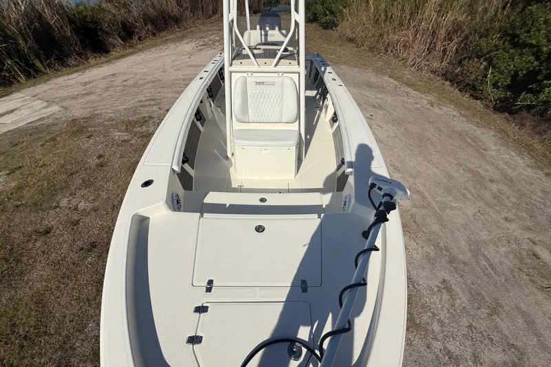 Slide: The Image of 2025 Pathfinder 2400 Open boat on a dirt path, featuring a spacious deck and Garmin equipment. - 23