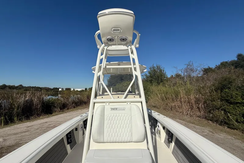 Slide: The Image of 2025 Pathfinder 2400 Open boat with tower, parked near a scenic waterway. - 25