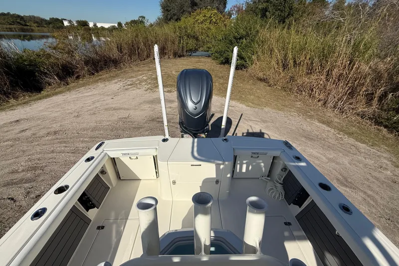Slide: The Image of 2025 Pathfinder 2400 Open boat with outboard motor, parked on a sandy shore. - 28