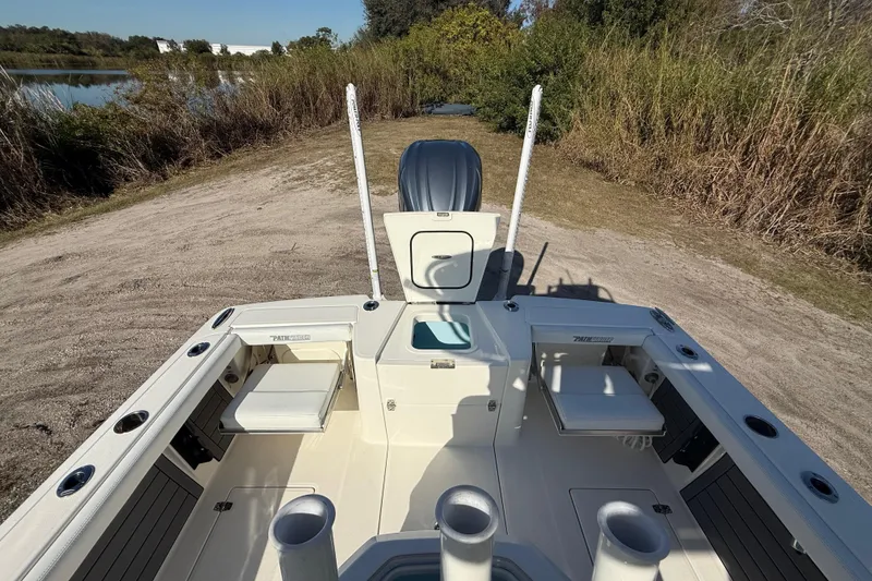 Slide: The Image of 2025 Pathfinder 2400 Open boat interior with seating and storage, set in a natural outdoor environment. - 29