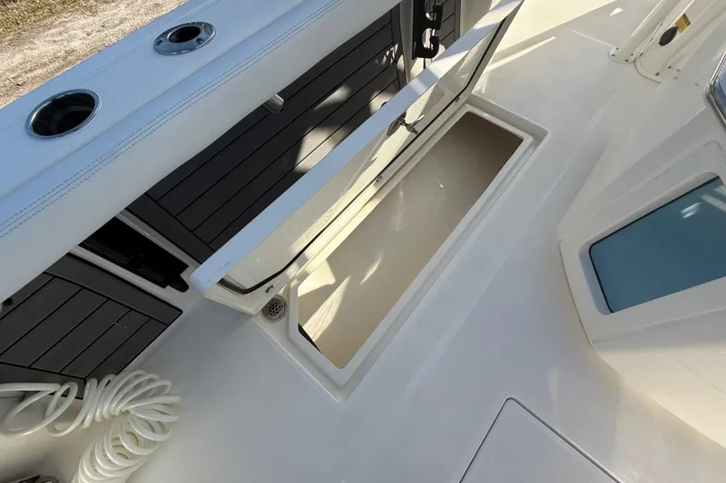 Slide: The Image of 2025 Pathfinder 2400 Open boat storage compartment with open hatch and coiled rope. - 34
