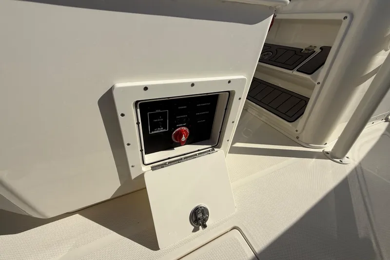 Slide: The Image of Control panel on 2025 Pathfinder 2400 Open boat, featuring a red switch and storage compartment. - 42