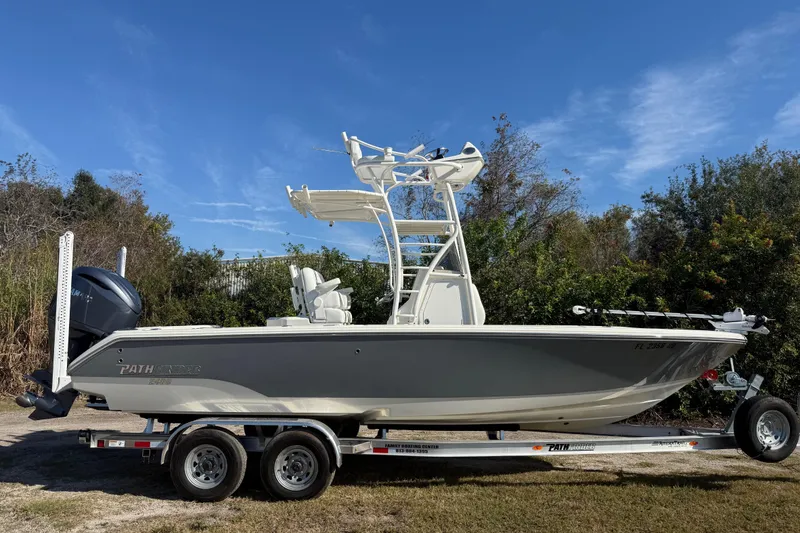 Slide: The Image of 2025 Pathfinder 2400 Open boat on trailer, parked outdoors under clear blue sky. - 8