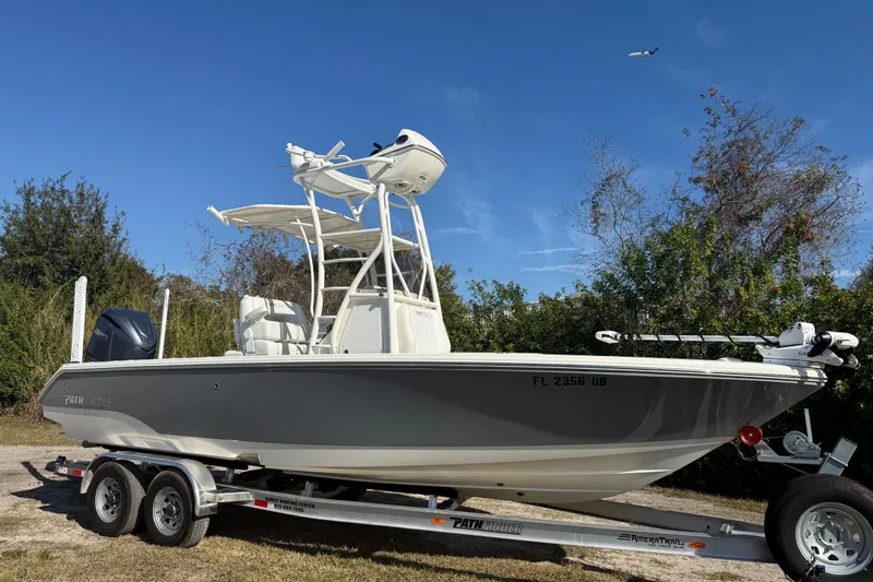 Slide: The Image of 2025 Pathfinder 2400 Open boat on trailer, parked outdoors under clear blue sky. - 9