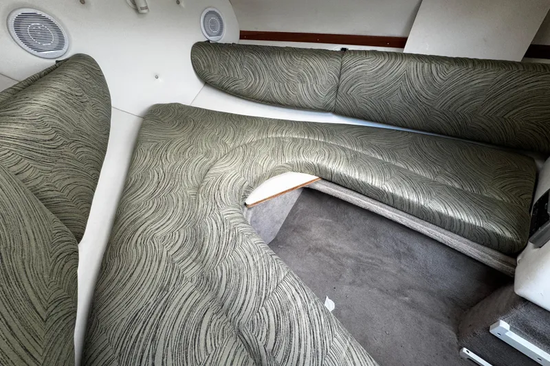 Slide: The Image of 2004 Four Winns 205 Sundowner cabin interior with patterned seating and carpeted floor. - 10