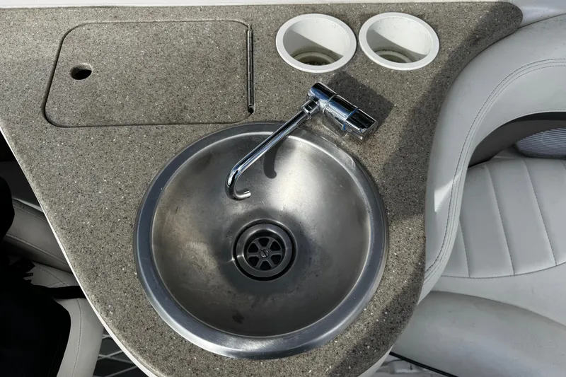 Slide: The Image of 2004 Four Winns 205 Sundowner boat sink with faucet and cup holders. - 14