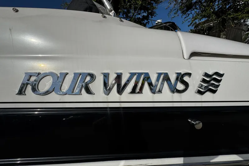 Slide: The Image of 2004 Four Winns 205 Sundowner boat logo on white hull, chrome lettering. - 23