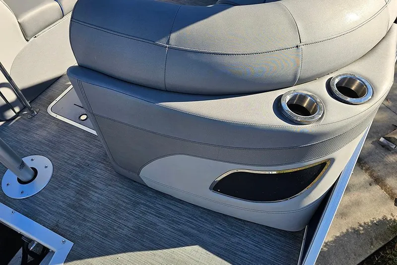 Slide: The Image of 2022 Bennington 24 LXFB boat interior with gray seating and cup holders. - 11