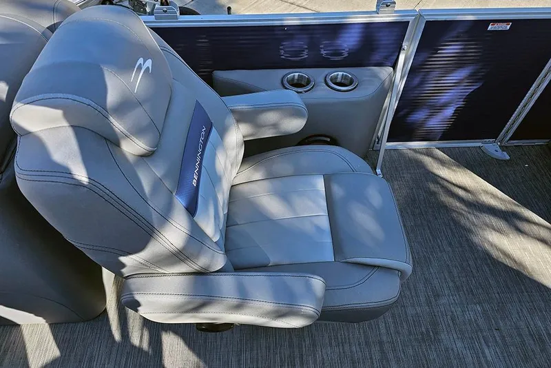 Slide: The Image of 2022 Bennington 24 LXFB boat seat with cup holders, featuring gray upholstery. - 17
