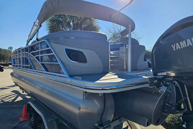 Slide: The Image of 2022 Bennington 24 LXFB pontoon boat with Yamaha engine, docked under sunny skies. - 3