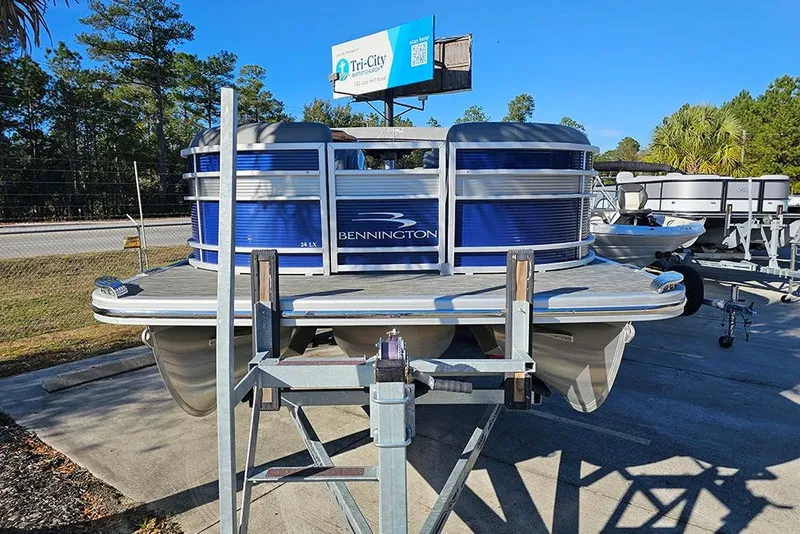 Slide: The Image of 2022 Bennington 24 LXFB pontoon boat on trailer, parked outdoors. - 4