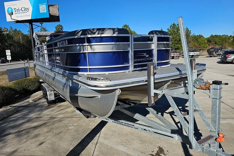 Slide: The Image of 2022 Bennington 24 LXFB pontoon boat on trailer in parking lot. - 5