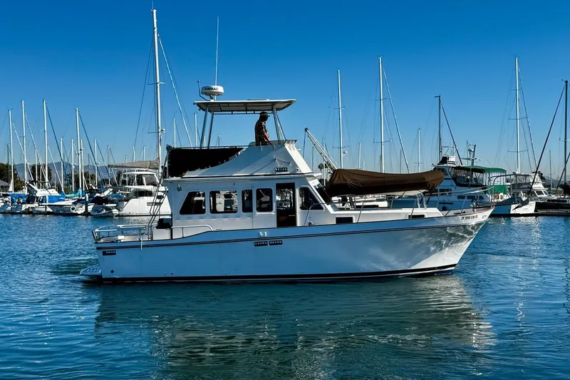 Slide: The Image of 1979 Californian 34 yacht docked in a marina, surrounded by sailboats under a clear blue sky. - 1