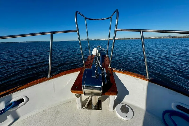Slide: The Image of Bow view of 1979 Californian 34 yacht on open water under clear blue sky. - 13