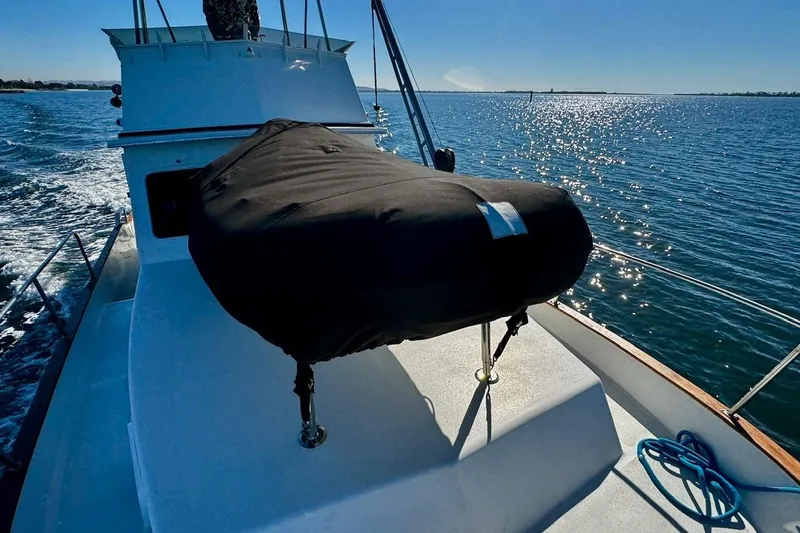 Slide: The Image of 1979 Californian 34 boat cruising on sunny waters, featuring covered equipment on deck. - 15