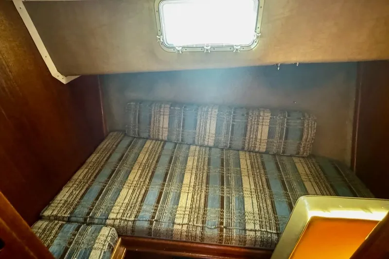Slide: The Image of Cozy cabin interior of 1979 Californian 34 boat with plaid cushions and window. - 33