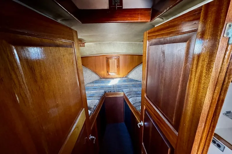 Slide: The Image of Interior cabin of a 1979 Californian 34 boat with wooden paneling and cozy bedding. - 35