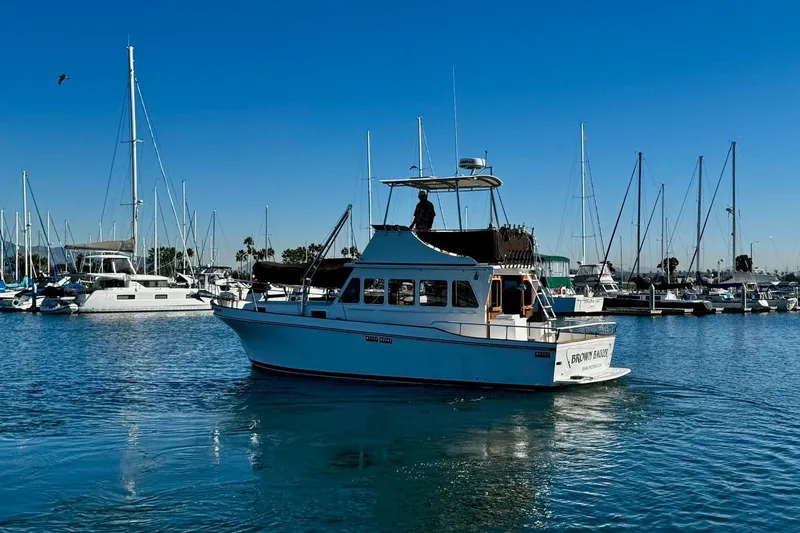 Slide: The Image of 1979 Californian 34 boat in marina, surrounded by sailboats under clear blue sky. - 6